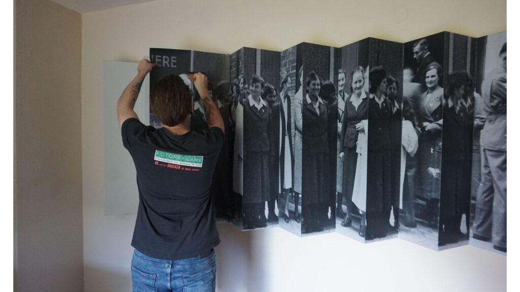 Permanent exhibition In the wake of the SS Leporello wall hanger is mounted by Fotoreklame staff