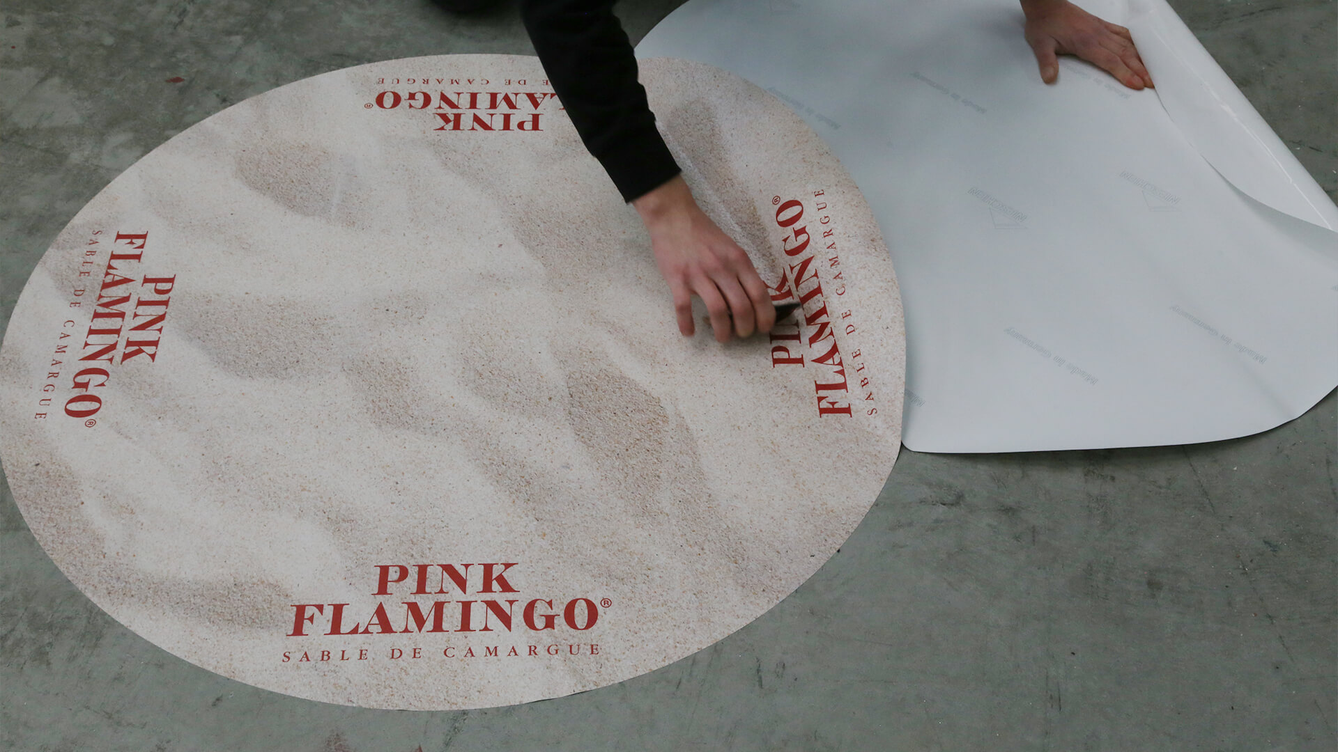 Pink Flamingo große runde Bodenfolien bei der Montage von Fotoreklame Mitarbeiter