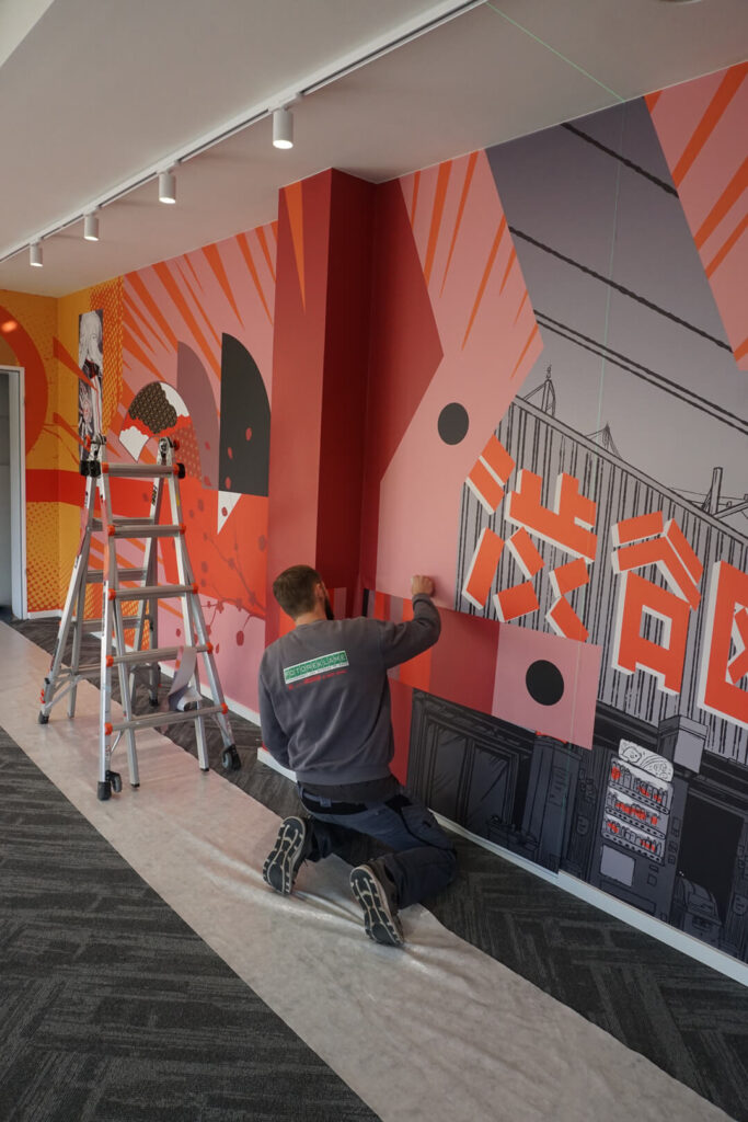 The Crunchyroll wallpaper is being installed by Fotoreklame staff.